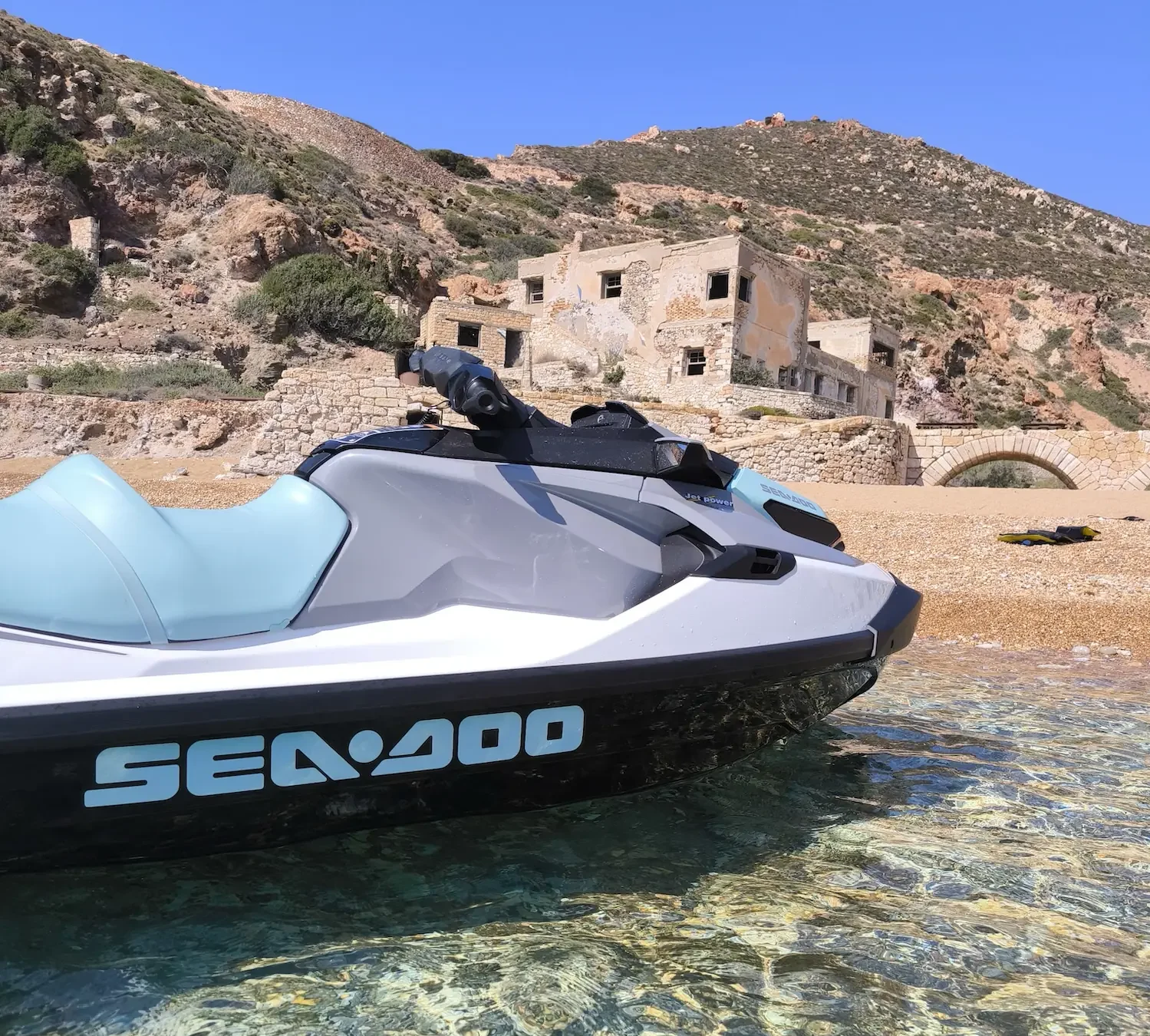 Sea-Doo jet ski on the beach below the old Sulfur Mines buildings in Milos