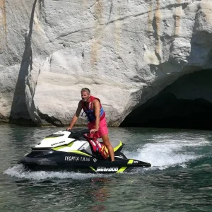 Nikos Xydous on a Sea-Doo jet ski by the white cliffs of Milos