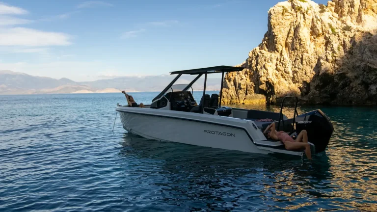 Protagon 25 with guests anchored by golden rocks at sunset