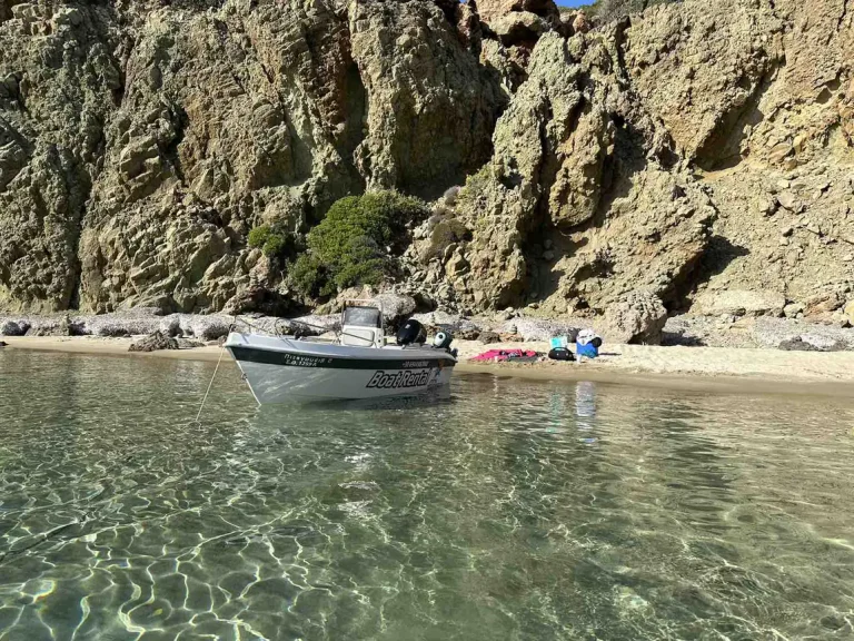 Tempest rental boat pulled up at a small beach under the rocks